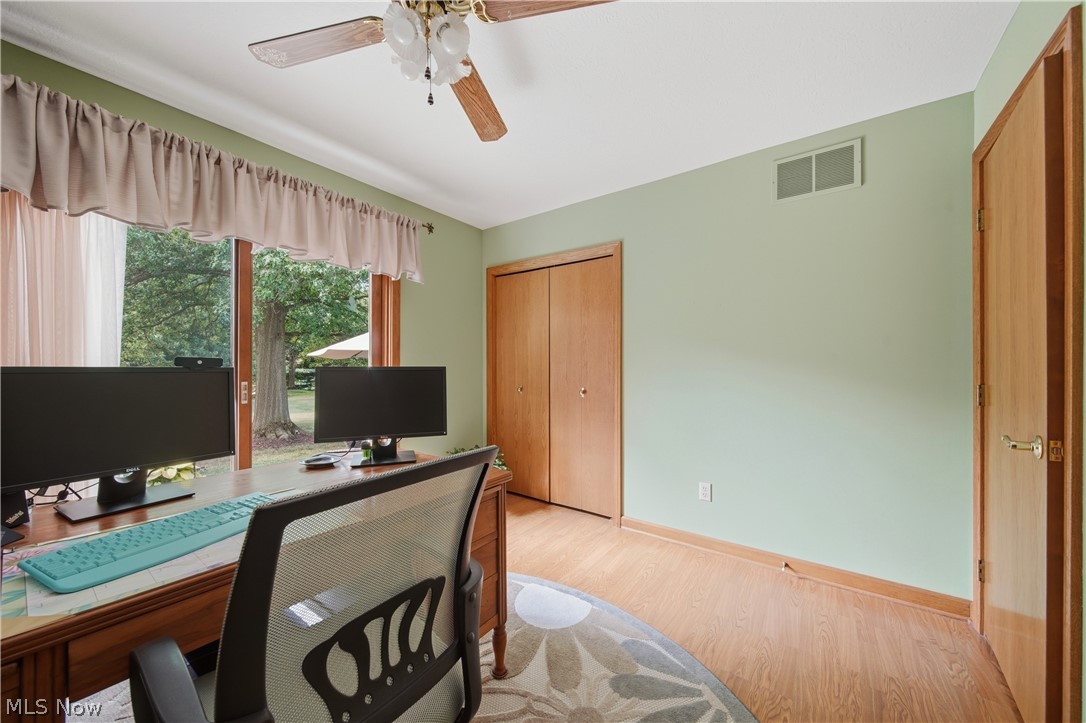 118 Manning Road Mogadore, OH 44260 - Photo 11 of 45 Room featuring wood-finish flooring, light green wall paint, and a ceiling fan with integrated lighting