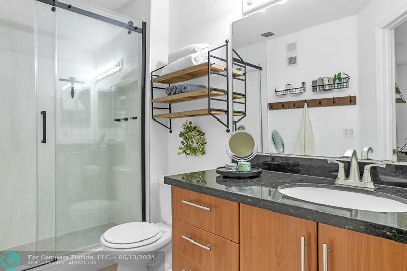 3410 Pinewalk Drive North, Unit 812 Pompano Beach, FL 33063 - Photo 11 of 26 a bathroom with a granite countertop sink a toilet and shower