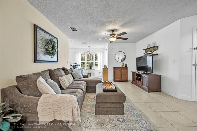 3410 Pinewalk Drive North, Unit 812 Pompano Beach, FL 33063 - Photo 4 of 26 a living room with furniture a flat screen tv and kitchen view