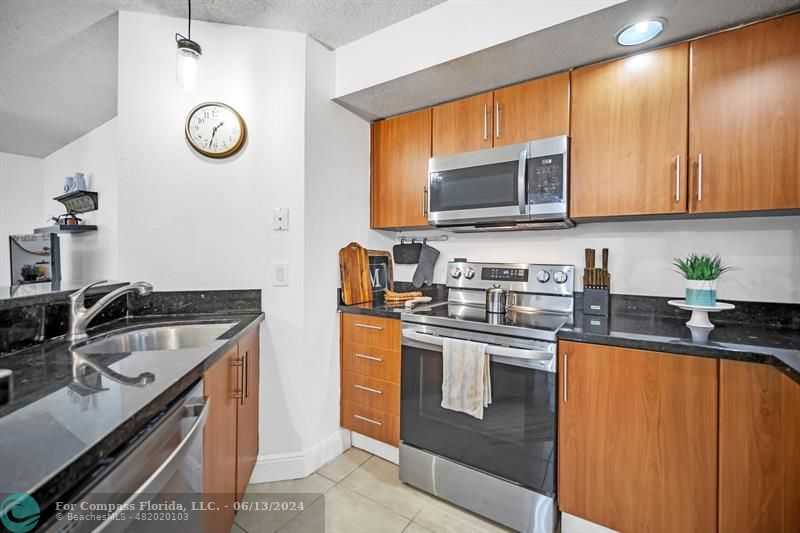 3410 Pinewalk Drive North, Unit 812 Pompano Beach, FL 33063 - Photo 7 of 26 a kitchen with stainless steel appliances granite countertop a sink stove and cabinets