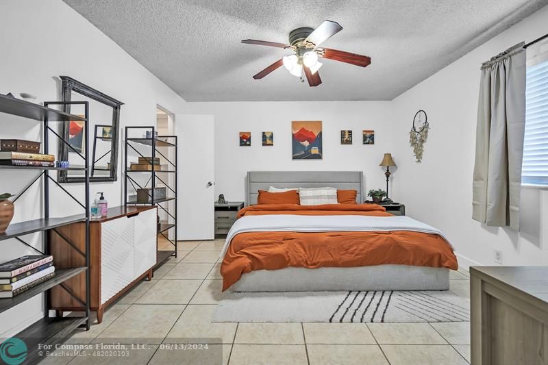 3410 Pinewalk Drive North, Unit 812 Pompano Beach, FL 33063 - Photo 9 of 26 a bedroom with a large bed and a chandelier
