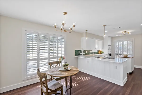 a kitchen with stainless steel appliances kitchen island a table and chairs in it