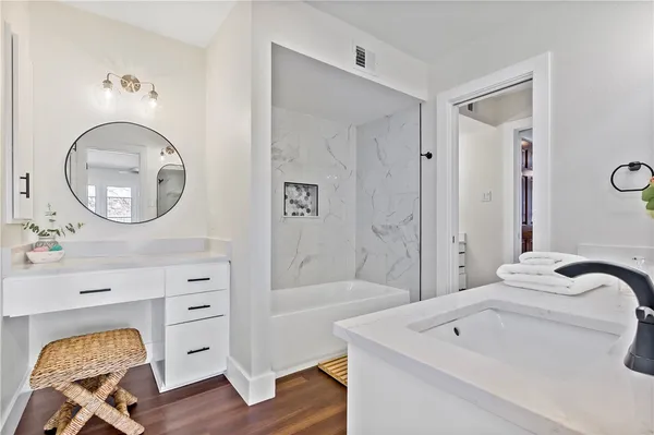 a bathroom with a tub sink and mirror