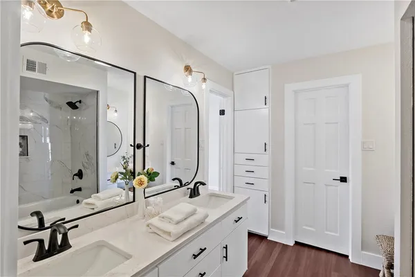 a bathroom with a double vanity sink a mirror and a shower