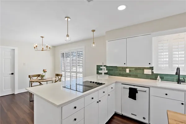 a kitchen with granite countertop white cabinets white appliances and a sink