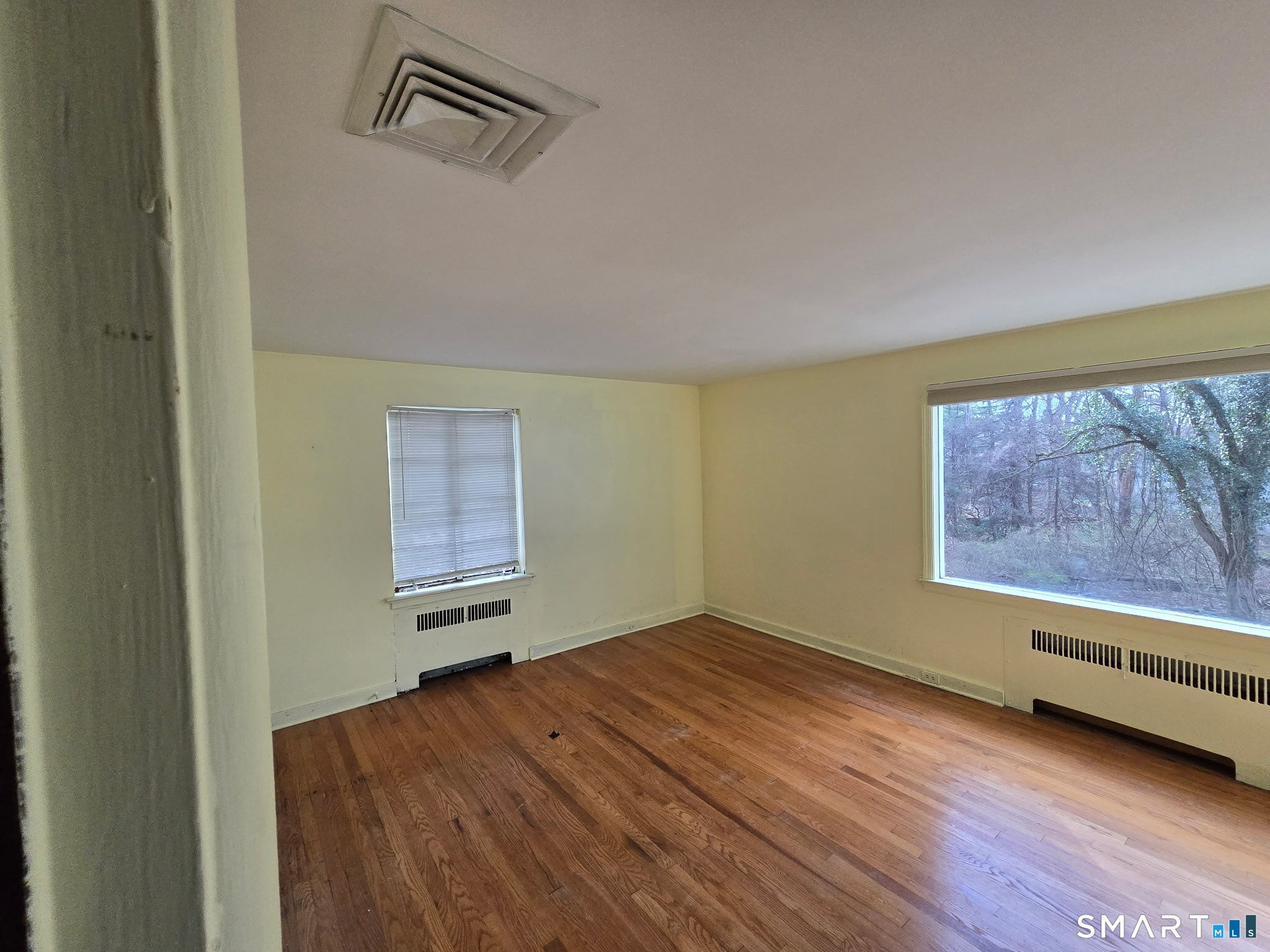 677 West Hill Road Stamford, CT 06902 - Photo 15 of 28 a view of an empty room with a window and wooden floor