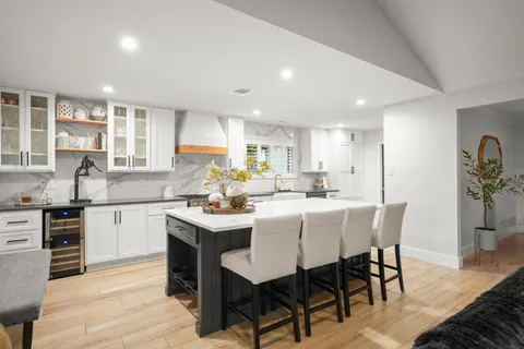 a kitchen with kitchen island granite countertop a sink cabinets and wooden floor