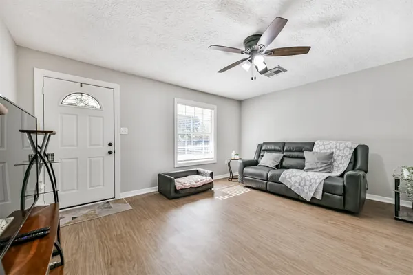 a living room with furniture a ceiling fan and a window