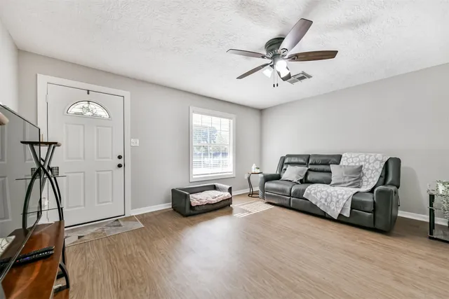 a living room with furniture a ceiling fan and a window