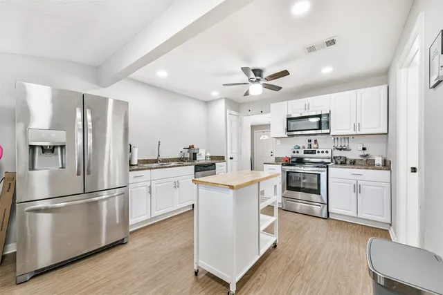a kitchen with white cabinets and stainless steel appliances