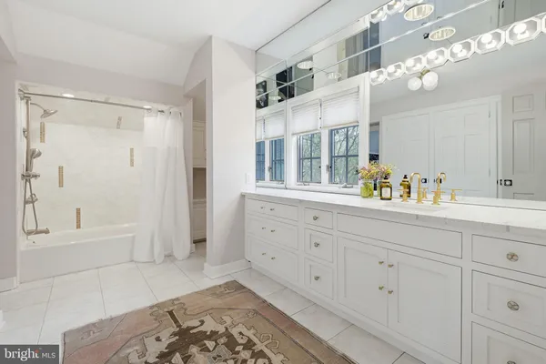 a spacious bathroom with a double vanity sink a mirror and a bathtub