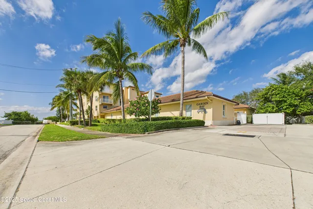 a bedroom with a bed a painting on the wall and a baby crib