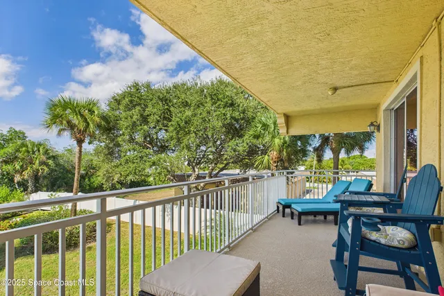 a view of swimming pool with a lounge chair and palm trees