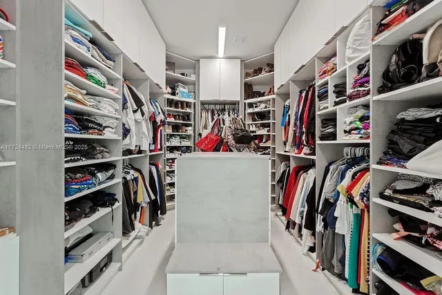 a view of walk in closet with clothes and shoes
