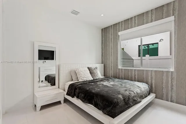 a bedroom with a bed and a flat screen tv