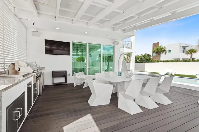 a view of a patio with table and chairs potted plants with floor to ceiling window