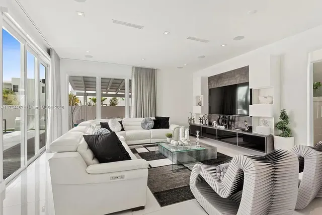 a living room with furniture a flat screen tv and a large window