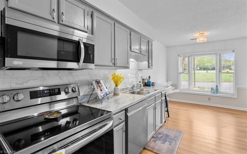 814 Guilford College Road, Unit 133 Greensboro, NC 27409 - Photo 2 of 18 New appliances and bay window in kitchen