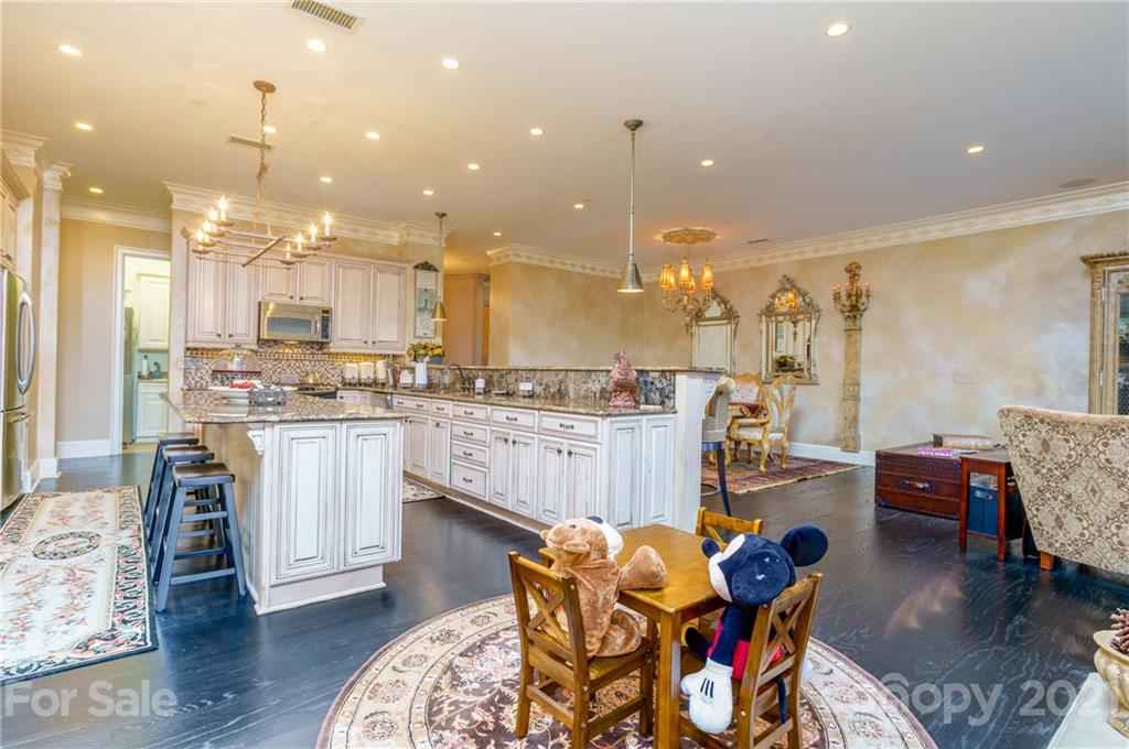 2823 Providence Road, Unit 235 Charlotte, NC 28211 - Photo 3 of 37 a kitchen with stainless steel appliances kitchen island granite countertop a refrigerator a stove a sink a dining table and chairs with wooden floor