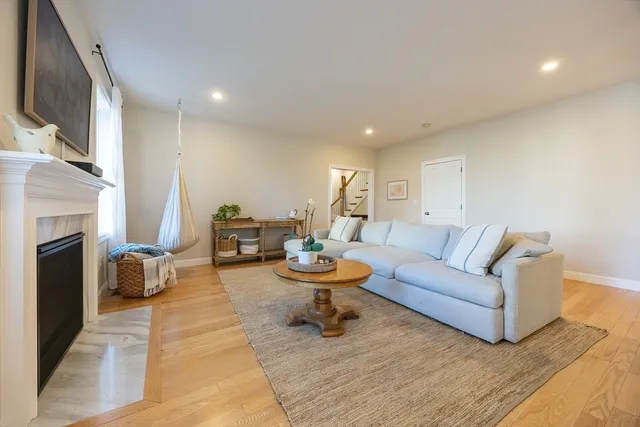 a view of a dining room and livingroom with furniture wooden floor a chandelier