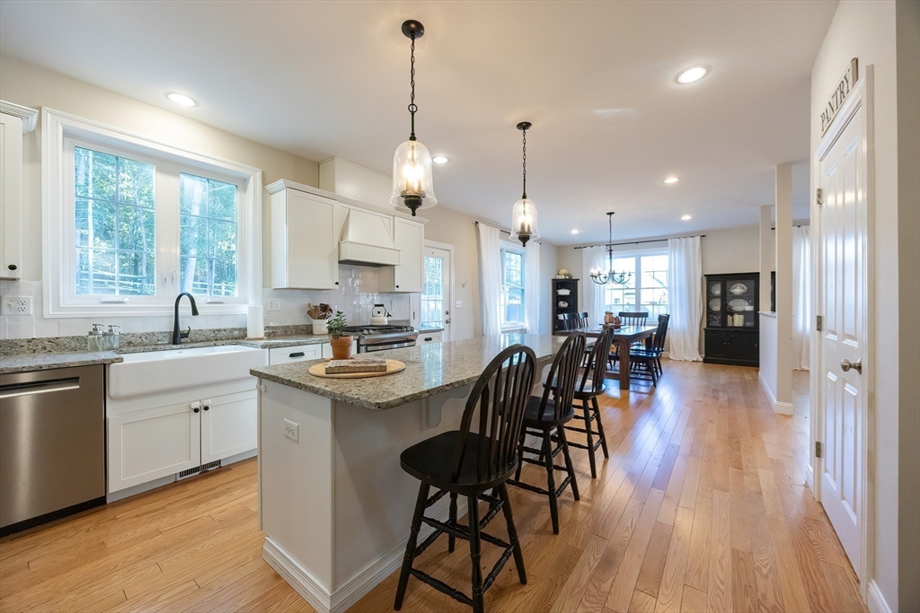 4 Sheppards Way Ipswich, MA 01938 - Photo 17 of 37 a kitchen with stainless steel appliances kitchen island granite countertop a stove a sink a refrigerator and a dining table with wooden floor