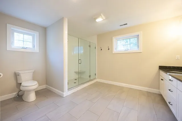 a bed sitting in a spacious bedroom next to a window