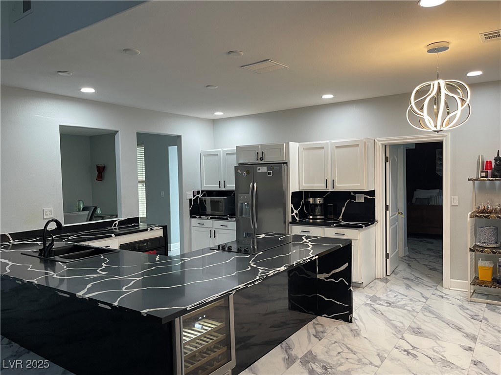 6480 West Oquendo Road Las Vegas, NV 89118 - Photo 15 of 51 Kitchen featuring light marble finish floors, a peninsula, stainless steel fridge with ice dispenser, decorative light fixtures, and recessed lighting