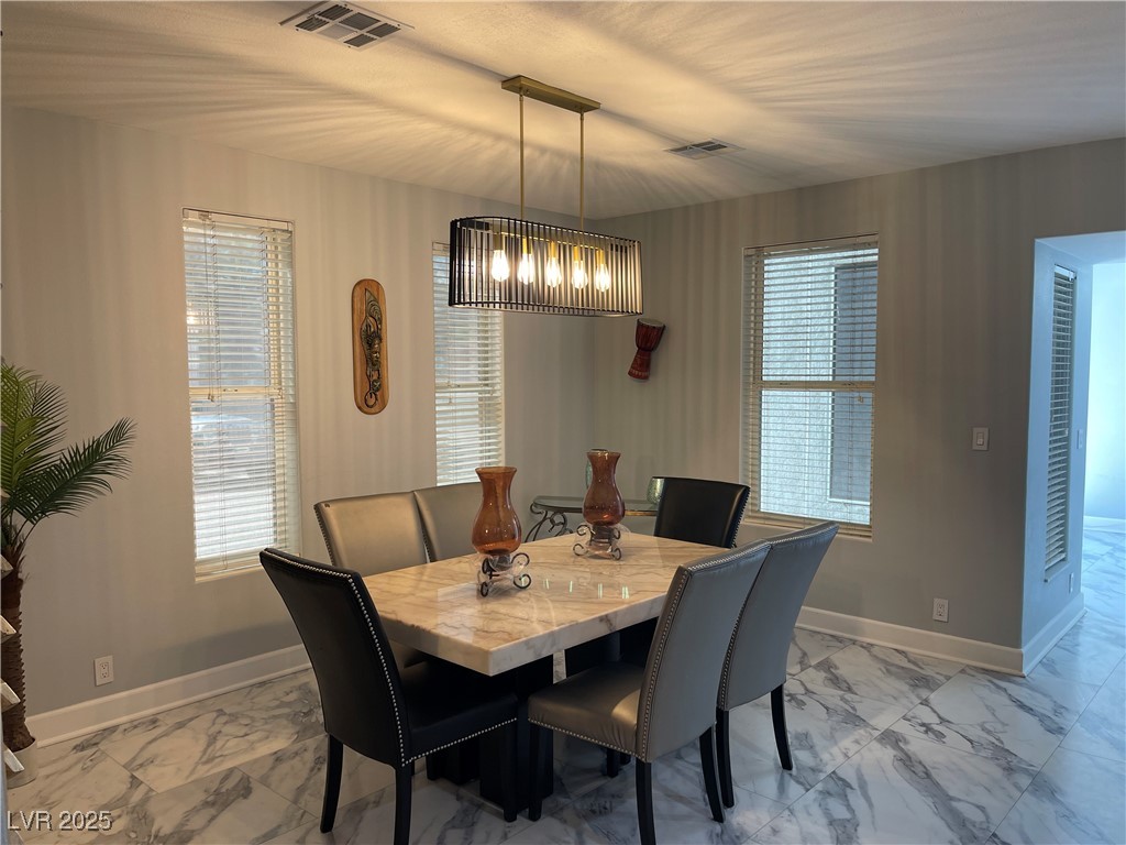 6480 West Oquendo Road Las Vegas, NV 89118 - Photo 24 of 51 Dining space featuring light marble finish floors and a chandelier