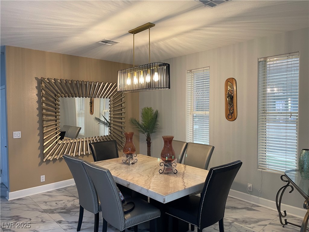 6480 West Oquendo Road Las Vegas, NV 89118 - Photo 25 of 51 Dining room featuring light marble finish flooring and a chandelier