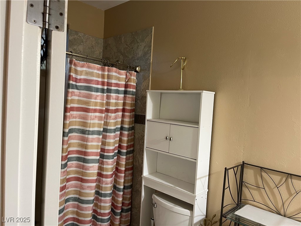 6480 West Oquendo Road Las Vegas, NV 89118 - Photo 27 of 51 Bathroom with a shower with shower curtain and a textured wall