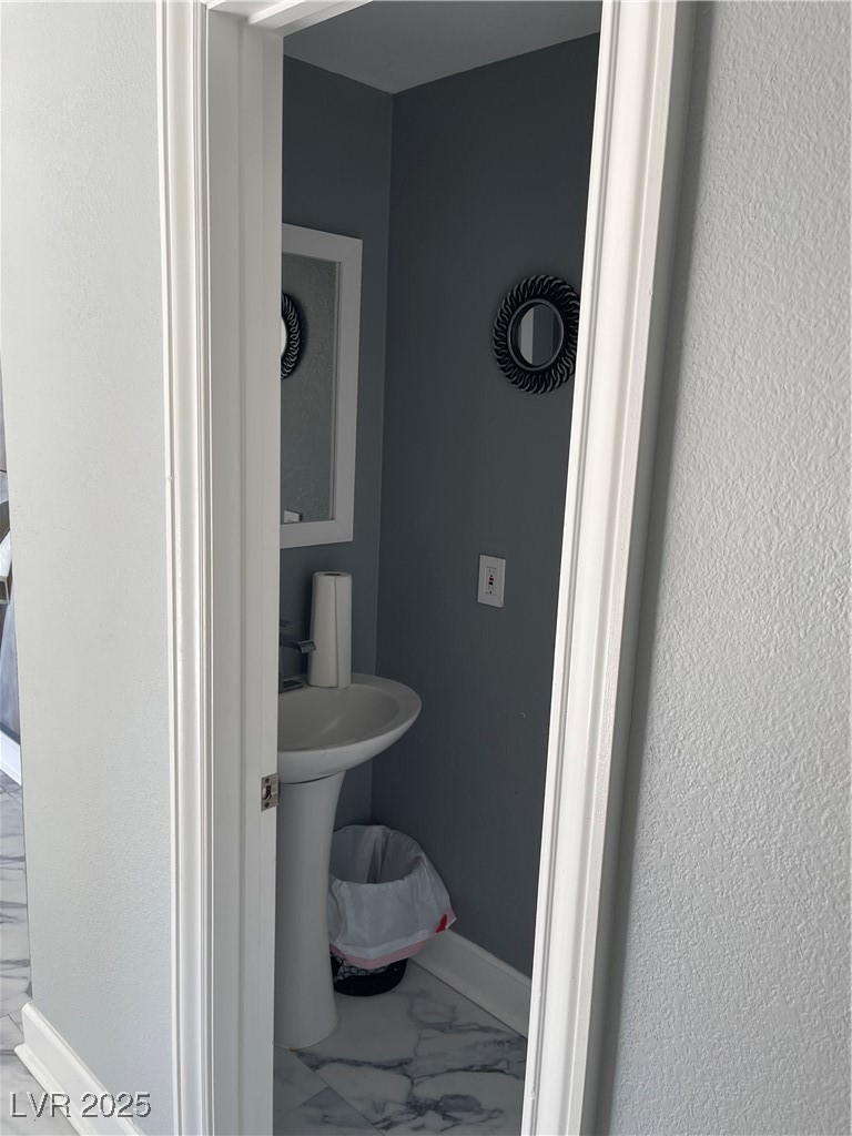 6480 West Oquendo Road Las Vegas, NV 89118 - Photo 28 of 51 Half bathroom featuring baseboards and marble look tiles