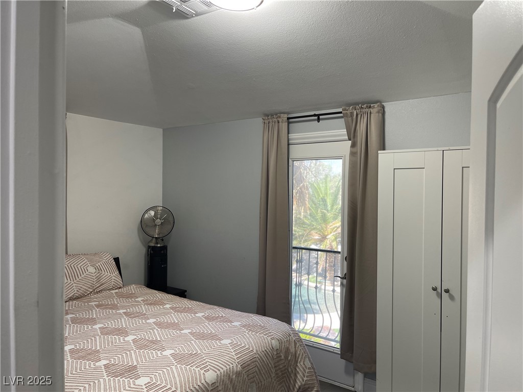 6480 West Oquendo Road Las Vegas, NV 89118 - Photo 32 of 51 Bedroom featuring a textured ceiling and access to outside