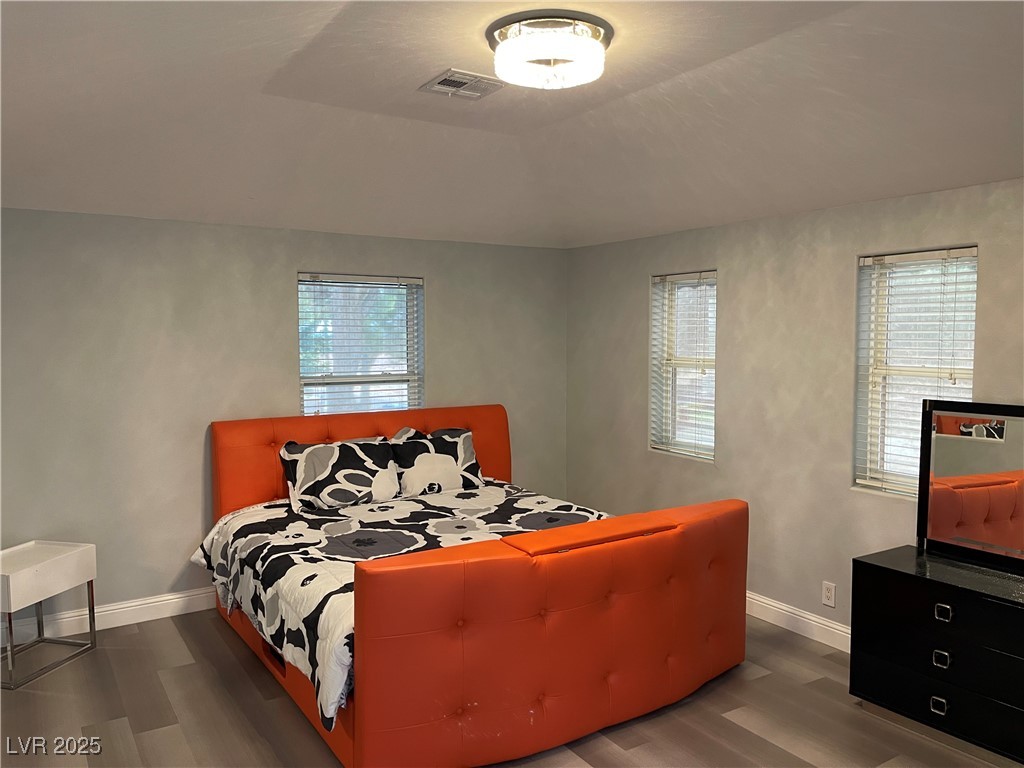 6480 West Oquendo Road Las Vegas, NV 89118 - Photo 39 of 51 Bedroom with dark wood-style flooring, multiple windows, and lofted ceiling