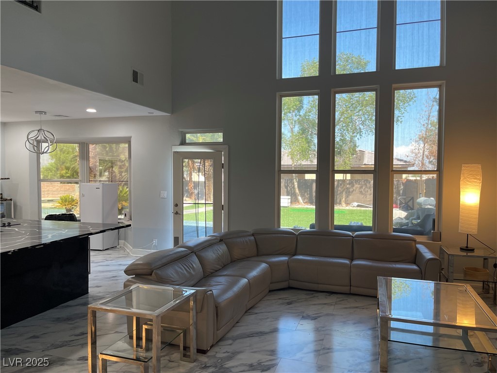 6480 West Oquendo Road Las Vegas, NV 89118 - Photo 8 of 51 Living room featuring light marble finish flooring and a high ceiling