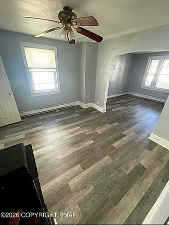 a view of empty room with window and ceiling fan