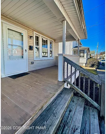 a view of a balcony with wooden floor and furniture