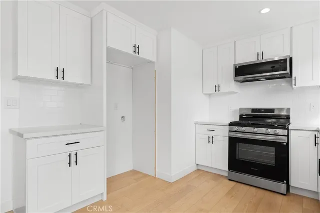 a kitchen with stainless steel appliances white cabinets and a stove