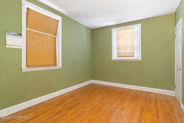 a view of a room with wooden floor and a window