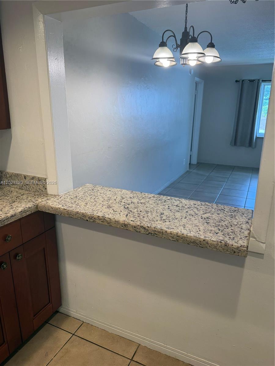 6841 Pembroke Road, Unit 15 Pembroke Pines, FL 33023 - Photo 7 of 16 a view of living room with granite countertop furniture and a chandelier