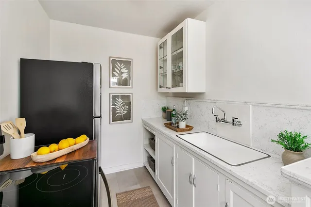 a kitchen with stainless steel appliances a sink a stove a refrigerator a microwave a counter top and cabinets