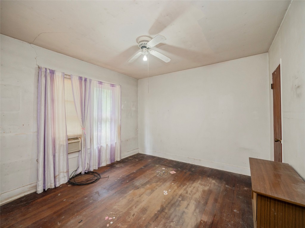 3104 South Main Street Taylor, TX 76574 - Photo 11 of 22 an empty room with wooden floor and windows