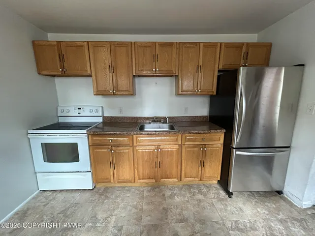 a kitchen with a refrigerator sink and cabinets