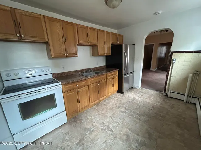 a kitchen with stainless steel appliances granite countertop a stove a refrigerator and a sink