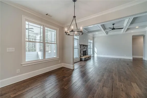 a view of empty room with wooden floor