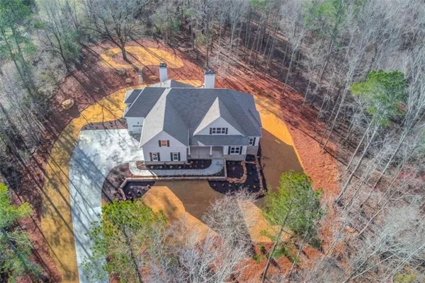 a view of an empty room with wooden floor and a ceiling fan