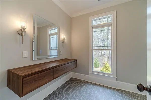 an empty room with chandelier fan and windows