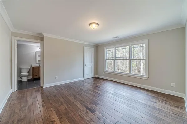 a front view of a house with a garden and trees