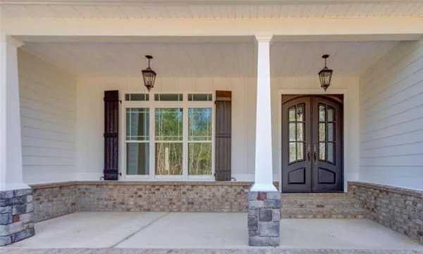 a view of an empty room with wooden floor fireplace and a window
