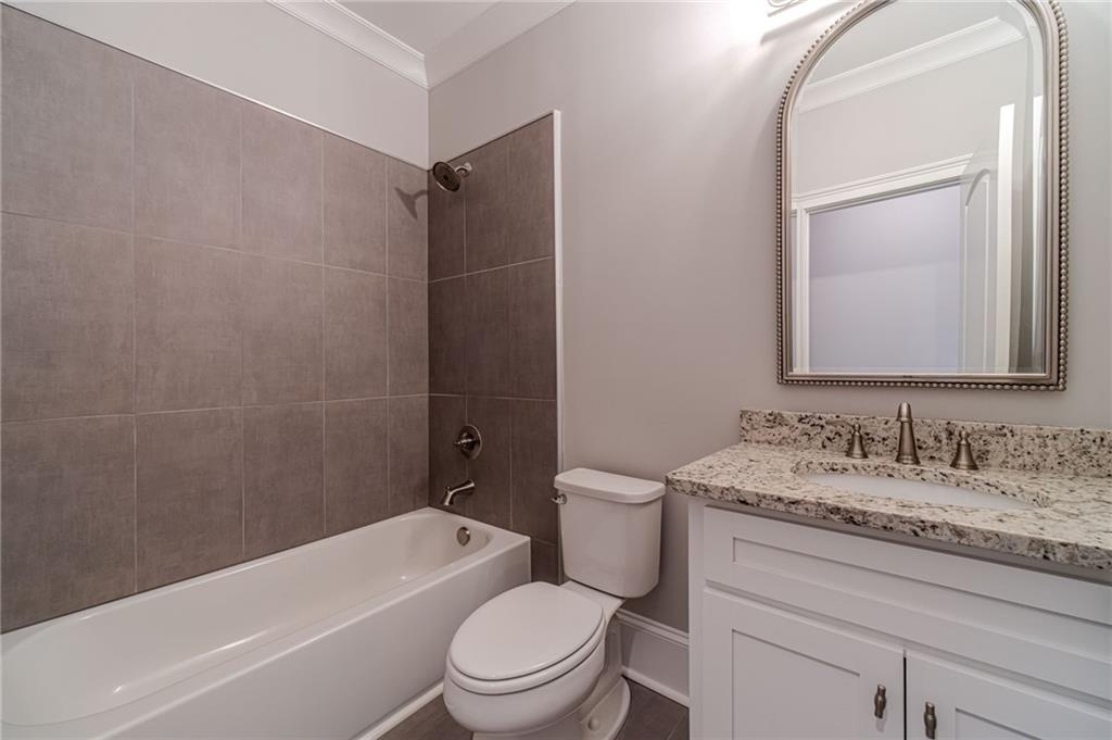 4720 Bold Springs Road Monroe, GA 30656 - Photo 52 of 83 a bathroom with a granite countertop toilet a sink and a bathtub