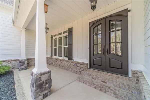 a view of an empty room with wooden floor and a ceiling fan